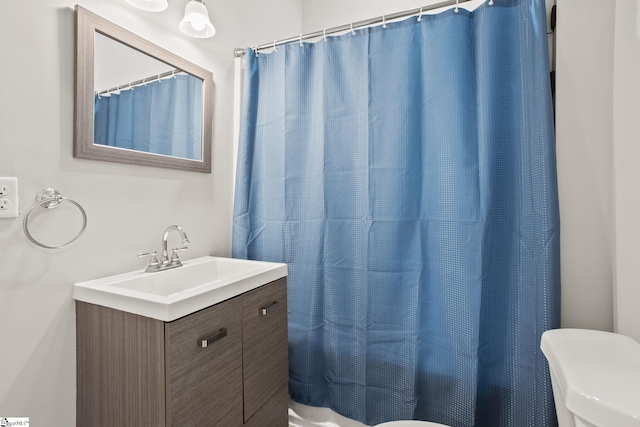 bathroom with shower / bath combination with curtain, toilet, and vanity