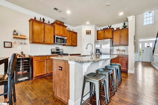 kitchen featuring stainless steel appliances, wine cooler, dark wood-style floors, a sink, and visible vents