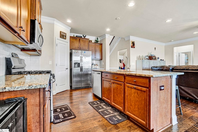 kitchen with stainless steel appliances, a sink, ornamental molding, and dark wood-style flooring