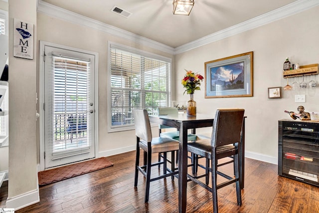 dining room with visible vents, beverage cooler, dark wood-type flooring, and crown molding