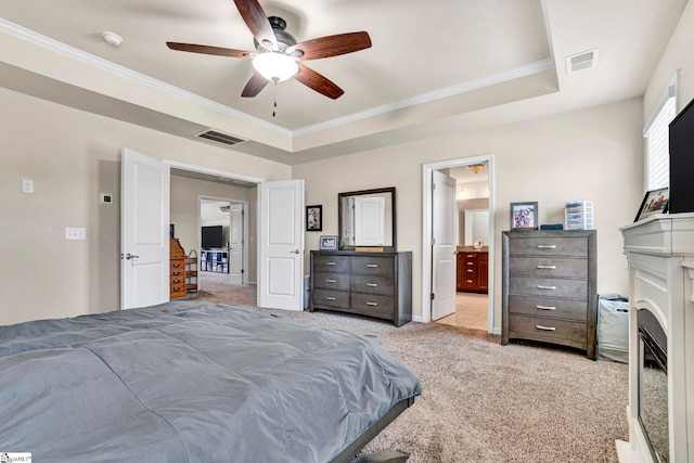 bedroom with a raised ceiling, visible vents, ornamental molding, light colored carpet, and ceiling fan