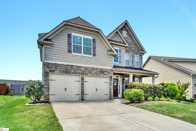 craftsman house featuring stone siding, an attached garage, a front lawn, and driveway