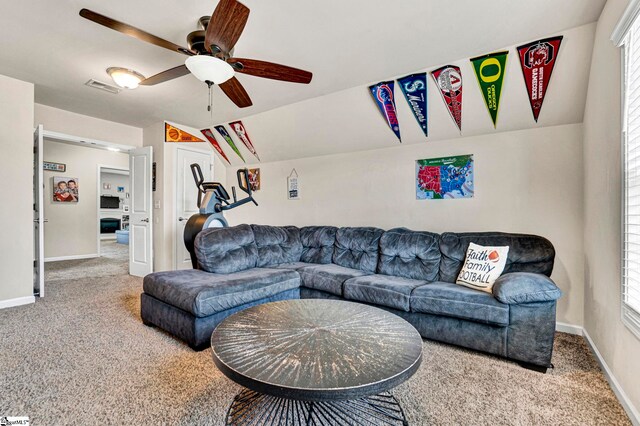 carpeted living area featuring vaulted ceiling, visible vents, a ceiling fan, a wealth of natural light, and baseboards