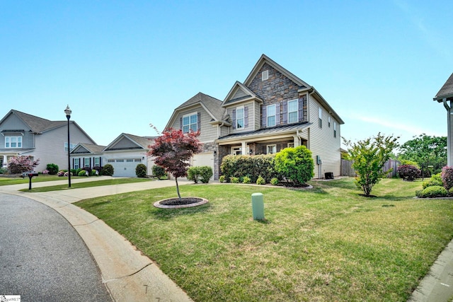 view of front of house featuring a standing seam roof, a front lawn, driveway, stone siding, and a garage