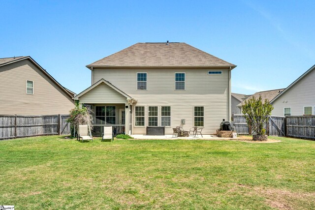 rear view of property with a fire pit, a patio area, a lawn, and a fenced backyard