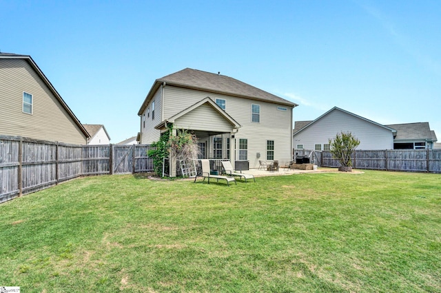 rear view of property featuring a lawn, a fenced backyard, and a patio