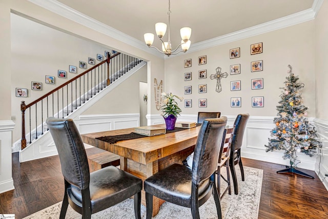 dining space with stairway, wainscoting, a chandelier, ornamental molding, and dark wood-type flooring