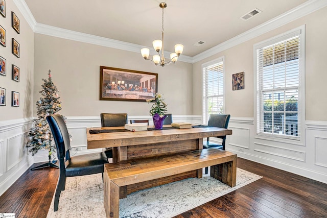 dining room featuring dark wood finished floors, an inviting chandelier, crown molding, and visible vents