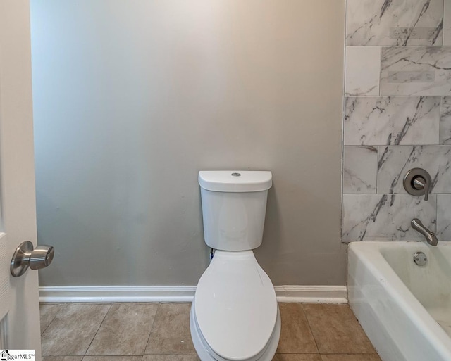 bathroom with shower / bathing tub combination, toilet, tile patterned floors, and baseboards