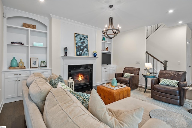 living room featuring a glass covered fireplace, recessed lighting, built in features, wood finished floors, and stairway