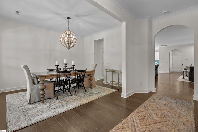 dining area with baseboards, wood finished floors, visible vents, and arched walkways