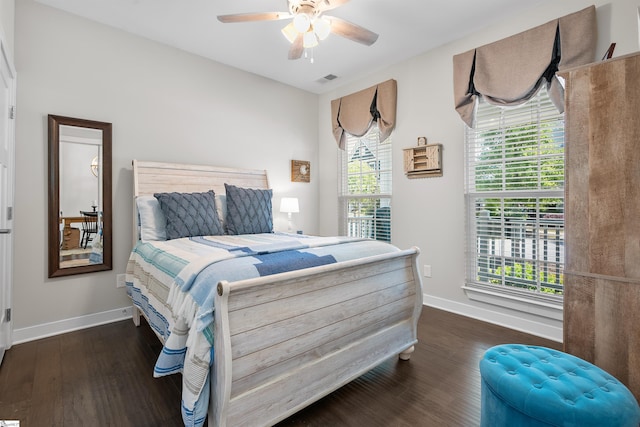 bedroom with wood finished floors, visible vents, baseboards, and ceiling fan