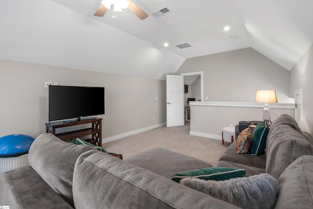 living area with baseboards, vaulted ceiling, visible vents, and light colored carpet
