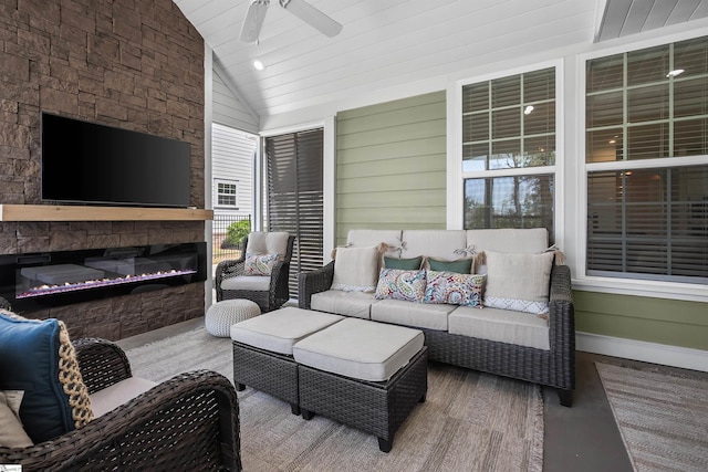 exterior space featuring an outdoor living space with a fireplace and a ceiling fan