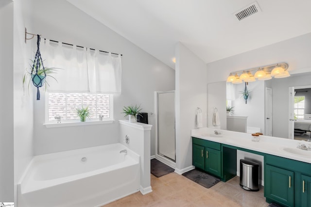 ensuite bathroom with a bath, a sink, double vanity, visible vents, and lofted ceiling
