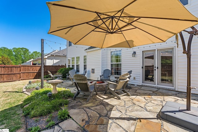 view of patio featuring fence and an outdoor fire pit