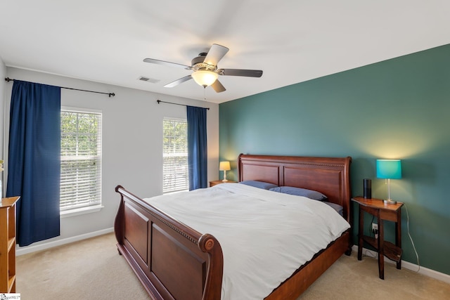bedroom featuring baseboards, visible vents, and light colored carpet