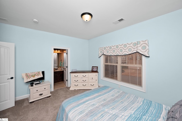 bedroom featuring connected bathroom, baseboards, carpet flooring, and visible vents