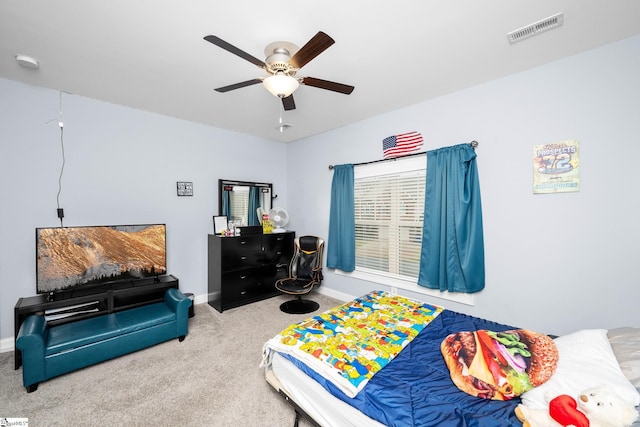 carpeted bedroom with baseboards, a ceiling fan, and visible vents