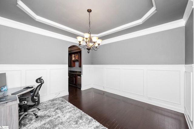 home office with a wainscoted wall, an inviting chandelier, a tray ceiling, arched walkways, and a decorative wall