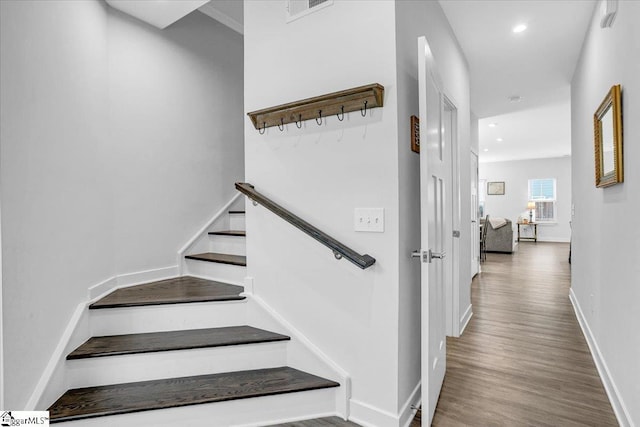 stairway featuring baseboards, wood finished floors, visible vents, and recessed lighting