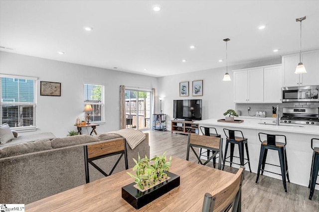 dining space with light wood-style flooring, visible vents, and recessed lighting