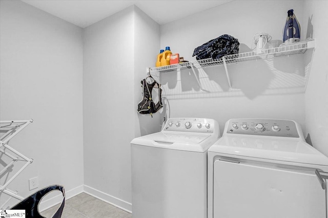 laundry area featuring separate washer and dryer, tile patterned floors, baseboards, and laundry area