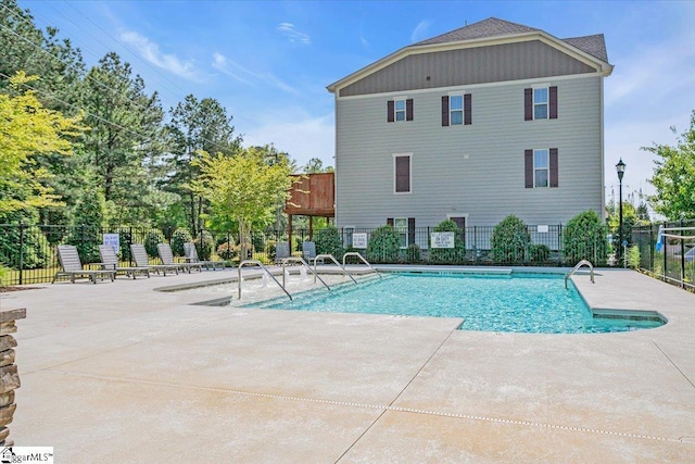 pool with a patio and fence