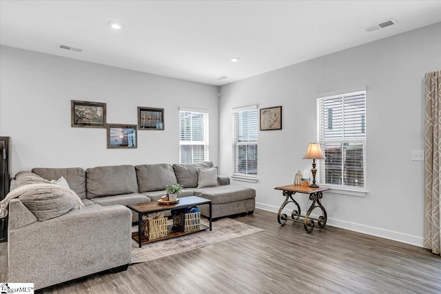 living area featuring baseboards, wood finished floors, visible vents, and recessed lighting