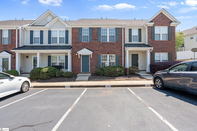 multi unit property featuring uncovered parking and brick siding