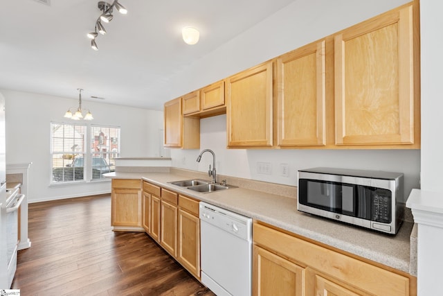kitchen featuring light brown cabinets, a sink, white appliances, and light countertops