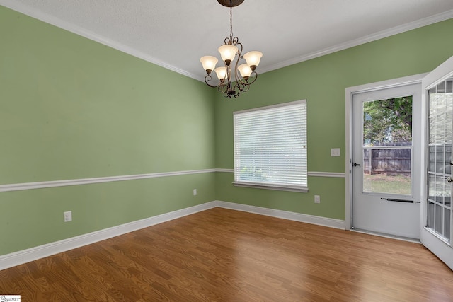 unfurnished room with a notable chandelier, wood finished floors, and plenty of natural light