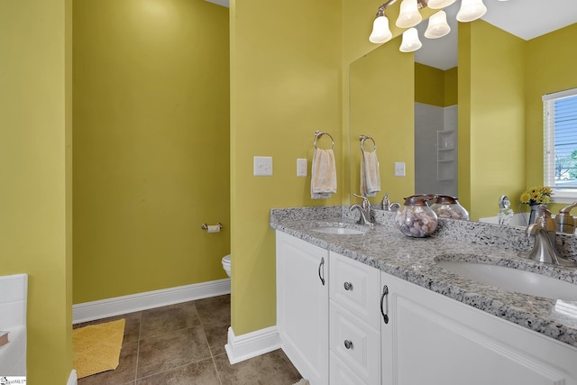 full bath with toilet, a notable chandelier, a sink, and baseboards