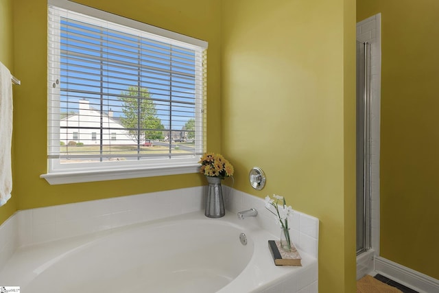 bathroom featuring a bath and a shower with shower door