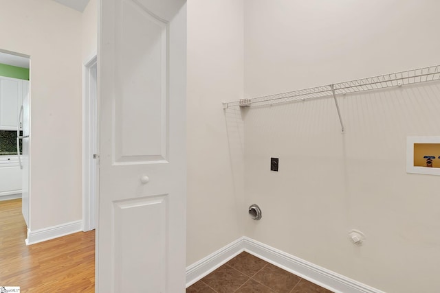 clothes washing area with hookup for an electric dryer, baseboards, gas dryer hookup, laundry area, and washer hookup