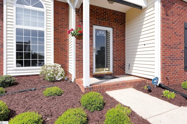 view of exterior entry featuring brick siding