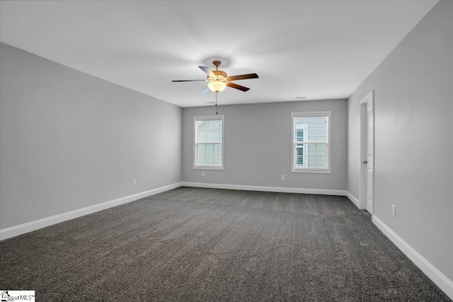 unfurnished room featuring dark carpet, a ceiling fan, and baseboards
