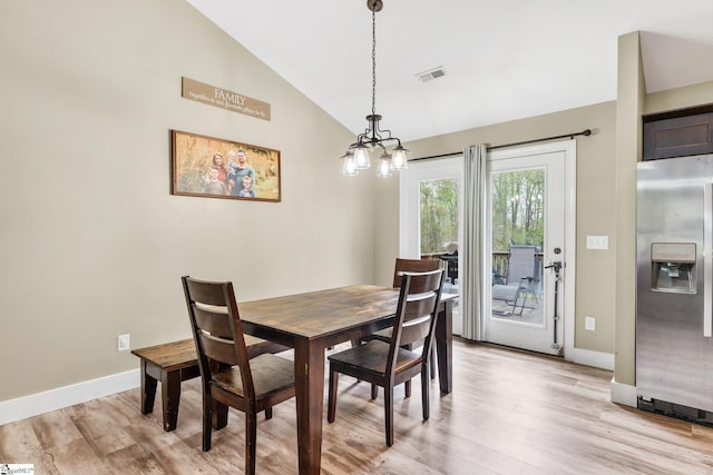 dining area featuring lofted ceiling, baseboards, light wood finished floors, and a notable chandelier