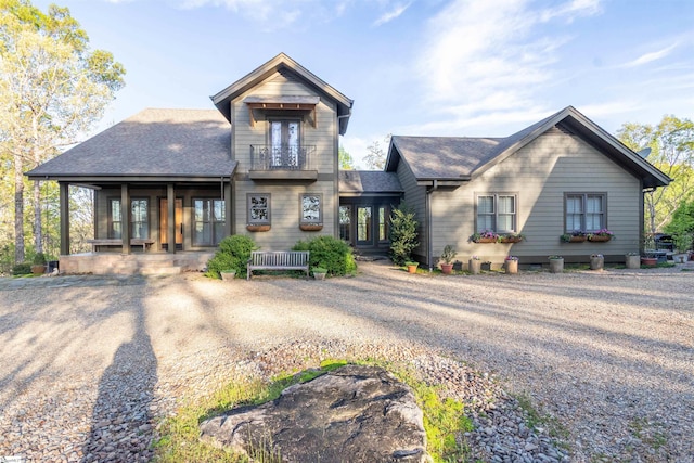view of front of home featuring french doors, a shingled roof, and a balcony