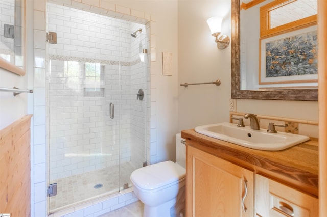 bathroom with a shower stall, toilet, and vanity