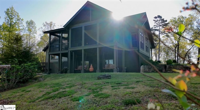 back of property featuring a lawn and a sunroom