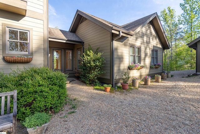 exterior space featuring roof with shingles