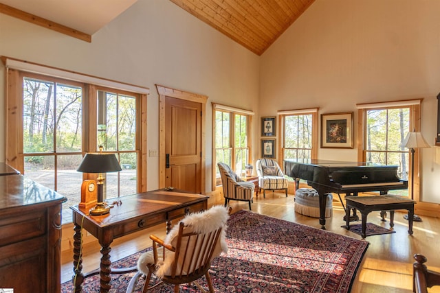 office space with wood ceiling, a wealth of natural light, wood finished floors, and high vaulted ceiling