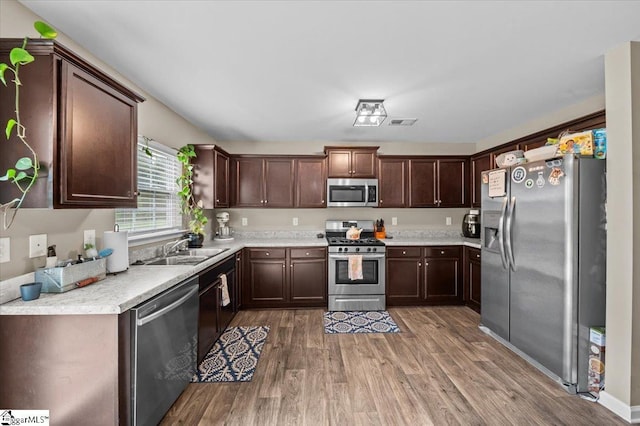 224 Hillendale Way, Pelzer, SC 29669 - kitchen with dark brown cabinets, a sink, light wood-style flooring, light countertops, and appliances with stainless steel finishes