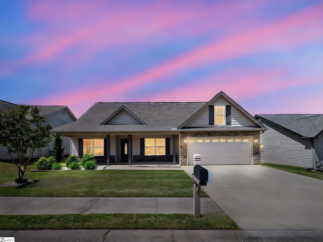 view of front facade with driveway, covered porch, stone siding, a lawn, and a garage