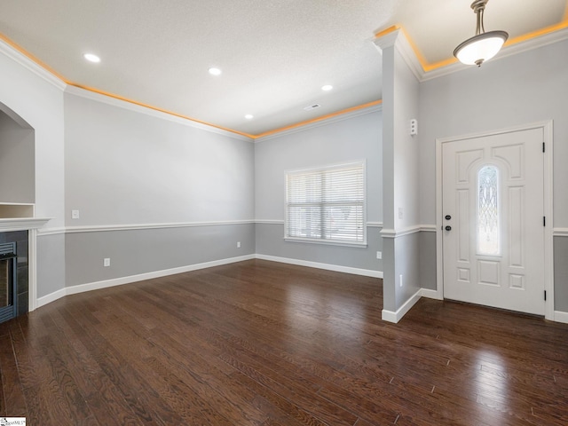entryway featuring baseboards, a fireplace, and ornamental molding