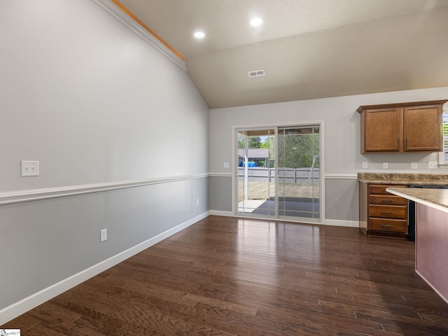 kitchen featuring dark wood-type flooring, lofted ceiling, visible vents, and brown cabinetry