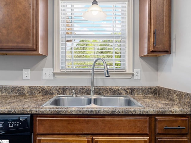 interior space with dark countertops, dishwashing machine, and a sink