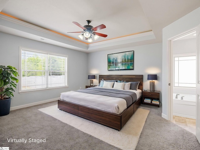 bedroom featuring connected bathroom, a tray ceiling, carpet, baseboards, and visible vents