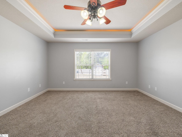 spare room with baseboards, a tray ceiling, carpet floors, and ceiling fan